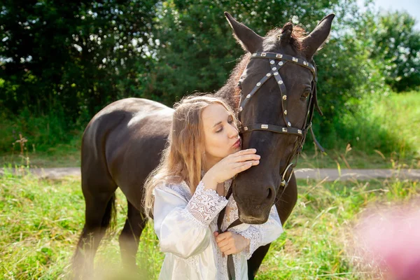 Красива біла молода дівчина гуляє з конем і насолоджується літнім часом у сільській місцевості . — стокове фото
