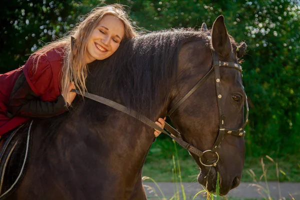 Krásná kavkazská mladá dívka kráčí s koněm a má léto na venkově. — Stock fotografie