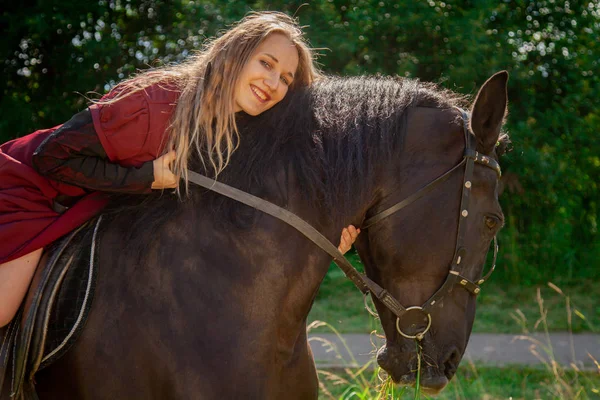 Gyönyörű kaukázusi fiatal lány séta egy ló, és élvezi a nyári vidéken. — Stock Fotó