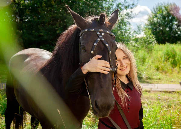 Красивая кавказская молодая девушка гуляет с лошадью и наслаждается летом в сельской местности . — стоковое фото