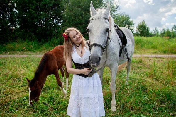 Bela menina caucasiana andando com um cavalo e gosta de verão no campo . — Fotografia de Stock