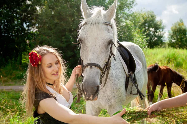 Bela menina caucasiana andando com um cavalo e gosta de verão no campo . — Fotografia de Stock