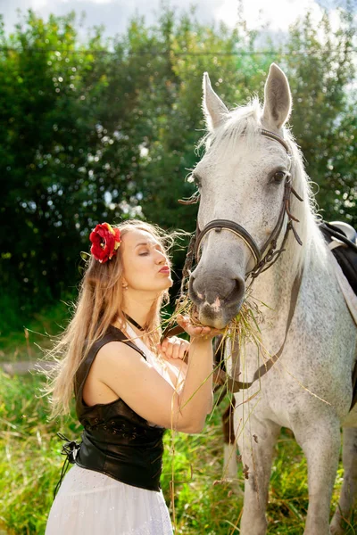 Bela menina caucasiana andando com um cavalo e gosta de verão no campo . — Fotografia de Stock