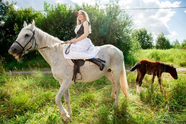 Bela menina caucasiana andando com um cavalo e gosta de verão no campo . — Fotografia de Stock