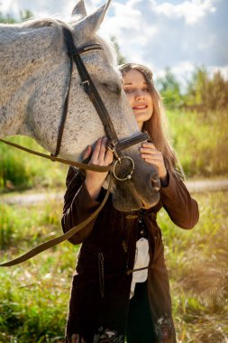 Güzel beyaz kız bir atla yürüyor ve yaz tatilini kırsalda geçiriyor..