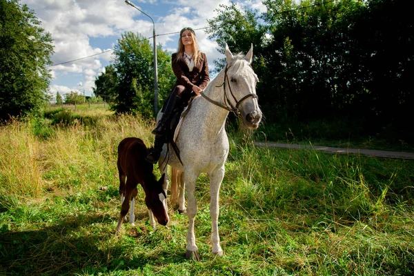 Mooi Kaukasisch jong meisje wandelen met een paard en geniet van de zomer op het platteland. — Stockfoto