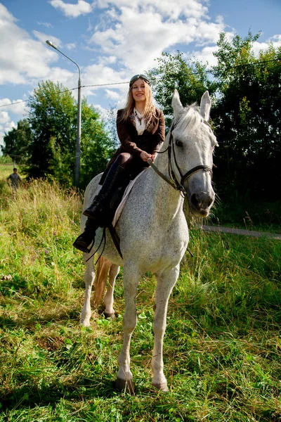 Schöne kaukasische junge Mädchen zu Fuß mit einem Pferd und genießt die Sommerzeit in der Natur. — Stockfoto