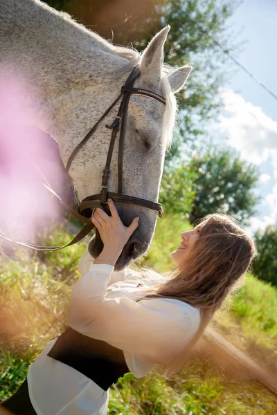 Beautiful caucasian young girl walking with a horse and enjoys summertime in countryside. — Stock Photo, Image
