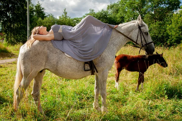 Bela menina caucasiana andando com um cavalo e gosta de verão no campo . — Fotografia de Stock