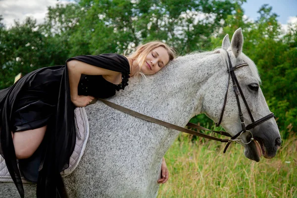 Beautiful caucasian young girl walking with a horse and enjoys summertime in countryside. — Stock Photo, Image