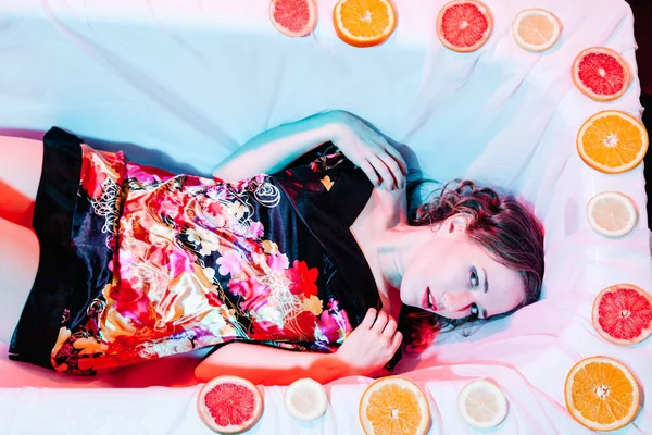 Mujer joven relajándose en la bañera de hidromasaje con rodajas de naranjas. Concepto de solidez . —  Fotos de Stock