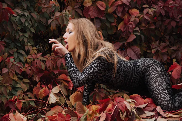 Mujer bastante caucásica en traje de leopardo futurista caminando en el parque de la ciudad — Foto de Stock