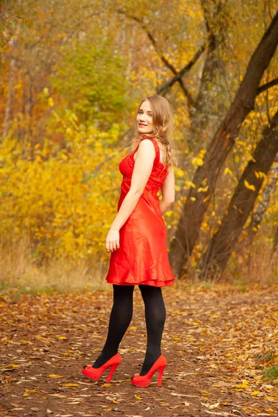 Mujer joven caminando en el fondo del jardín de otoño solo — Foto de Stock