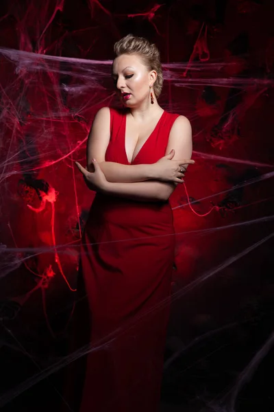 Mujer en vestido clásico de noche posando sobre fondo negro de Halloween con tela de araña —  Fotos de Stock