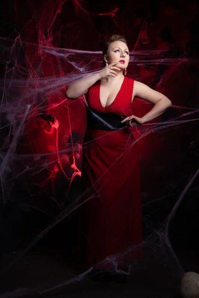 Frau in klassischem Abendkleid posiert auf schwarzem Halloween-Hintergrund mit Spinnennetz — Stockfoto
