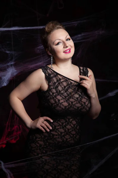 Donna in abito classico da sera in posa su sfondo nero Halloween con ragnatela — Foto Stock
