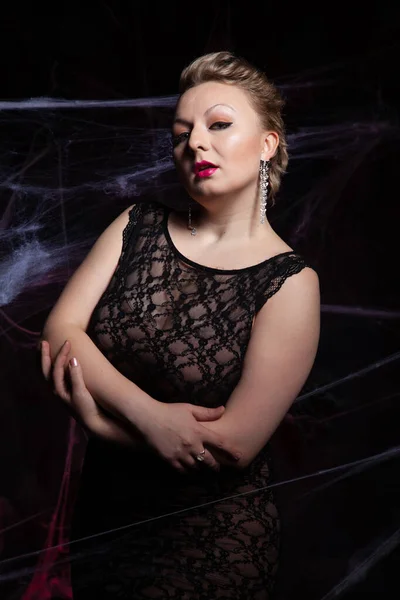 Donna in abito classico da sera in posa su sfondo nero Halloween con ragnatela — Foto Stock
