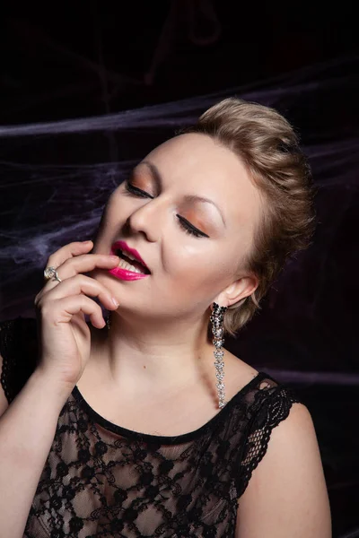 Mujer en vestido clásico de noche posando sobre fondo negro de Halloween con tela de araña — Foto de Stock