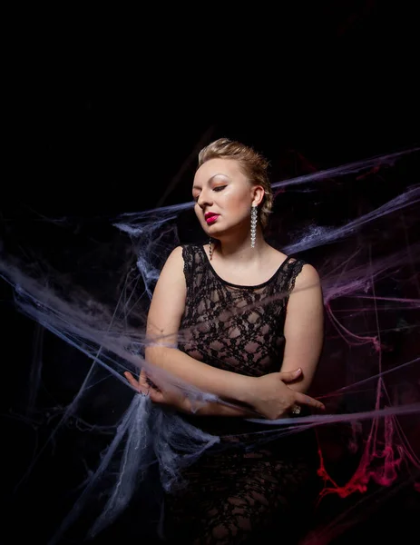 Woman in evening classic dress posing on black Halloween background with spider web — Stock Photo, Image