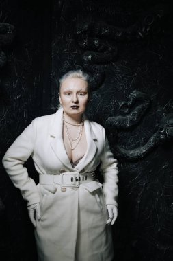 Stüdyoda siyah arka planda beyaz elbiseli sıradışı bir kızın portresi. Kadın artı boyut albino. Her insanda güzellik kavramı