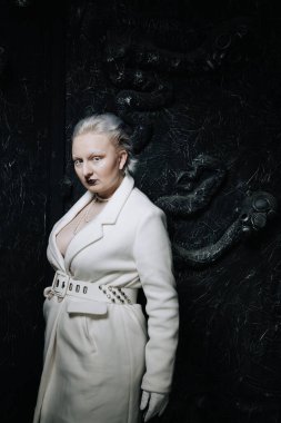 Stüdyoda siyah arka planda beyaz elbiseli sıradışı bir kızın portresi. Kadın artı boyut albino. Her insanda güzellik kavramı