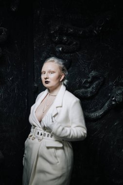 Stüdyoda siyah arka planda beyaz elbiseli sıradışı bir kızın portresi. Kadın artı boyut albino. Her insanda güzellik kavramı