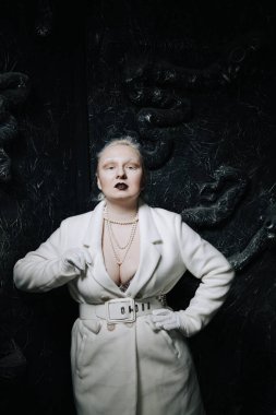 Stüdyoda siyah arka planda beyaz elbiseli sıradışı bir kızın portresi. Kadın artı boyut albino. Her insanda güzellik kavramı