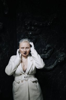 Stüdyoda siyah arka planda beyaz elbiseli sıradışı bir kızın portresi. Kadın artı boyut albino. Her insanda güzellik kavramı