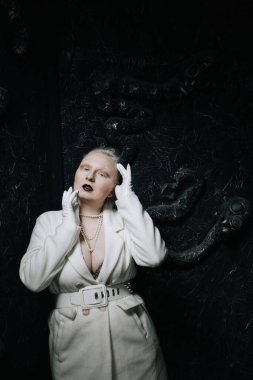 Stüdyoda siyah arka planda beyaz elbiseli sıradışı bir kızın portresi. Kadın artı boyut albino. Her insanda güzellik kavramı