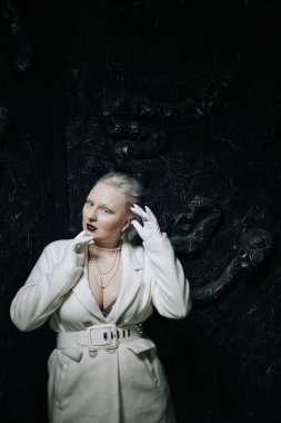 Stüdyoda siyah arka planda beyaz elbiseli sıradışı bir kızın portresi. Kadın artı boyut albino. Her insanda güzellik kavramı