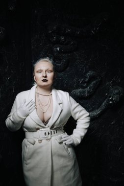 Stüdyoda siyah arka planda beyaz elbiseli sıradışı bir kızın portresi. Kadın artı boyut albino. Her insanda güzellik kavramı