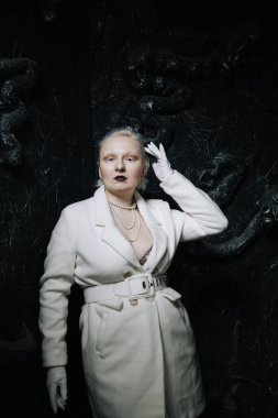 Stüdyoda siyah arka planda beyaz elbiseli sıradışı bir kızın portresi. Kadın artı boyut albino. Her insanda güzellik kavramı