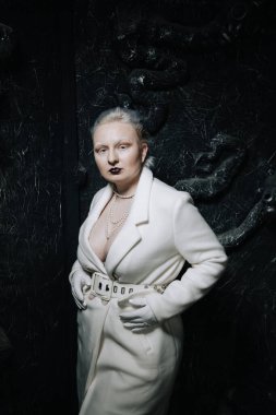 Stüdyoda siyah arka planda beyaz elbiseli sıradışı bir kızın portresi. Kadın artı boyut albino. Her insanda güzellik kavramı