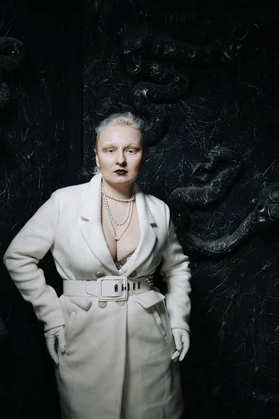 Stüdyoda siyah arka planda beyaz elbiseli sıradışı bir kızın portresi. Kadın artı boyut albino. Her insanda güzellik kavramı