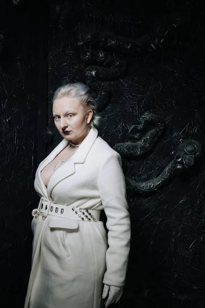 Stüdyoda siyah arka planda beyaz elbiseli sıradışı bir kızın portresi. Kadın artı boyut albino. Her insanda güzellik kavramı