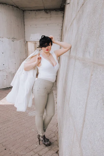 Jovem bela mulher elegante em casaco de lã branca andando pela rua. Além de tamanho cabelo curto menina adulta posando sozinha . — Fotografia de Stock