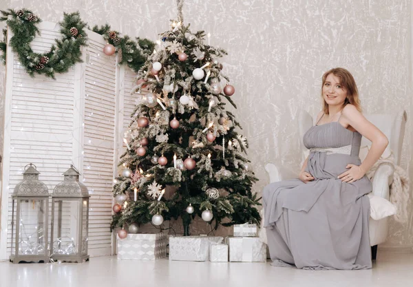 Donna felice incinta festeggia il Natale in camera decorata con abete di nuovo anno — Foto Stock