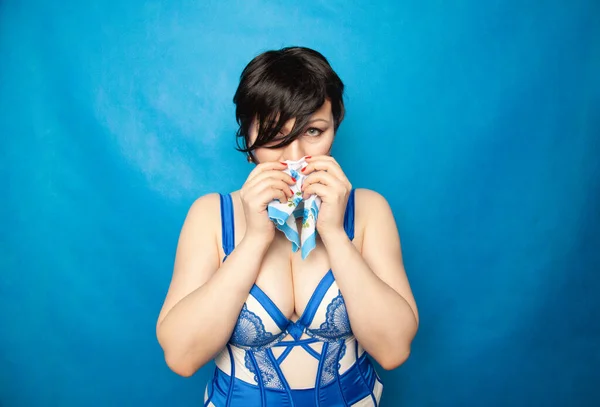 Bella giovane donna piangendo dalla miseria delle allergie e il raffreddore comune, asciugando le lacrime con un tovagliolo su sfondo blu — Foto Stock