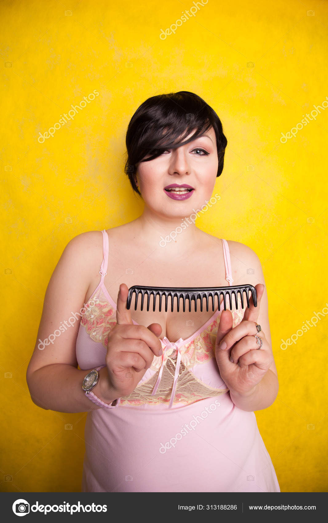 Secador de cabelo preto na mão de uma mulher em um fundo amarelo