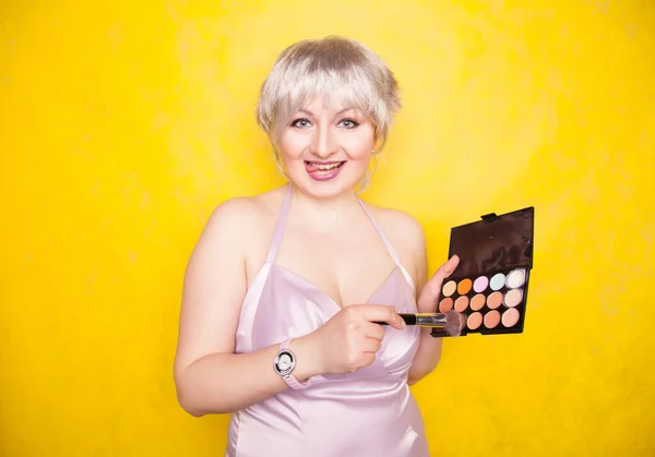Happy plus velikost žena baví s make-up paleta set a štětec. Profesionální vícebarevná paleta korektoru obličeje. — Stock fotografie