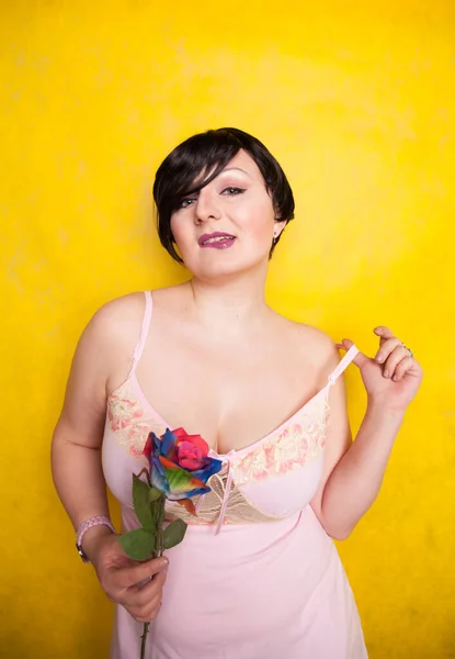 Hermosa mujer con flor artificial sobre fondo amarillo —  Fotos de Stock