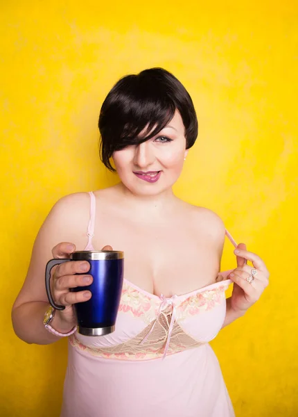 スタジオで黄色の背景に青い魔法瓶を持つ魅力的な女の子 — ストック写真