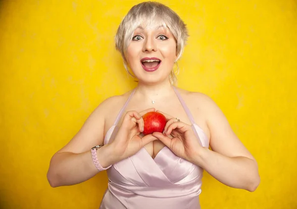 Крупним планом гарненька молода жінка тримає яблучні шельфи, щоб з'їсти — стокове фото