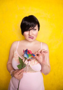 Sarı arka planda suni çiçekli güzel bir kadın.