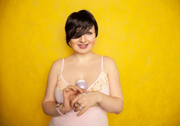 Muchacha atractiva poniendo crema anti-envejecimiento en su brazo de palma — Foto de Stock