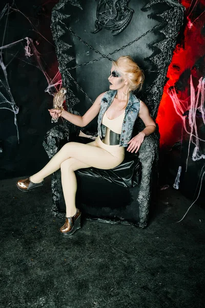 Modelo de Halloween de moda con pájaro sentado en el gran trono negro solo en la noche de miedo —  Fotos de Stock