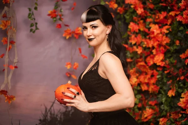 İnce moda cadılar bayramı kızı dantelli siyah saçlı sonbahar arka planında sonbahar yapraklarıyla poz veren gotik elbise. — Stok fotoğraf