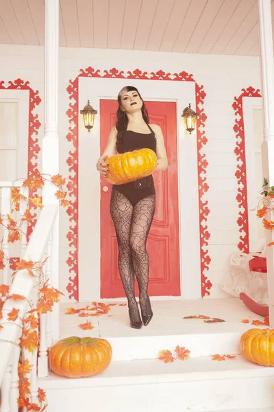Mulher sexy quente vir para truque ou tratar noite de Halloween. Menina vampiro gótico no alpendre branco da casa de outono decorada . — Fotografia de Stock