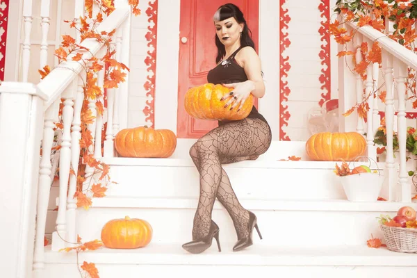 Hot sexy woman come for trick or treat halloween night. Gothic vampire girl on white porch of decorated autumn house. — 스톡 사진