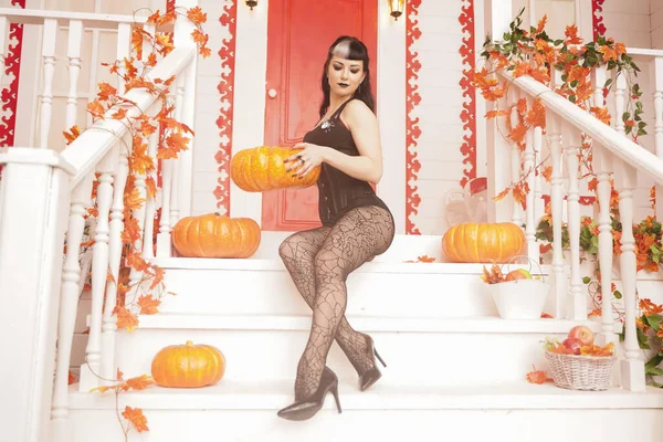 Hot sexy woman come for trick or treat halloween night. Gothic vampire girl on white porch of decorated autumn house. — 스톡 사진